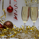 Two glasses of champagne with red and gold Christmas decorations