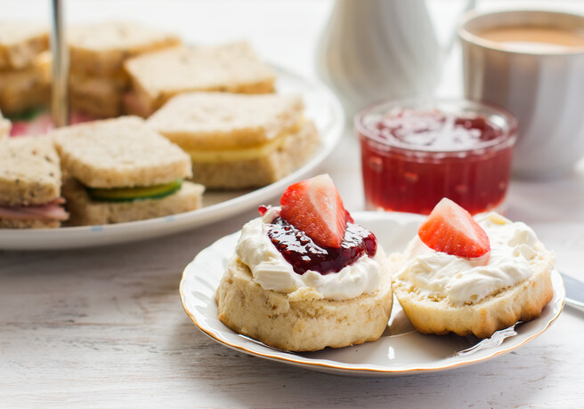 Image of an afternoon tea with sandwiches and a cream tea scone.