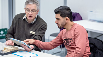 Conversation Cafe participant practicing with a volunteer.