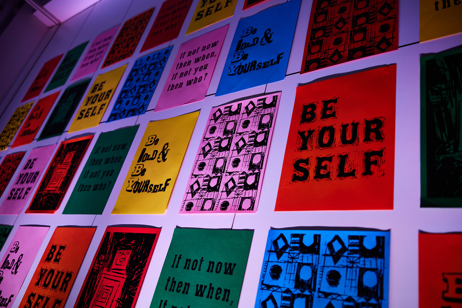 Selection of colourful screen-prints on display with text including 'Be Your Self'